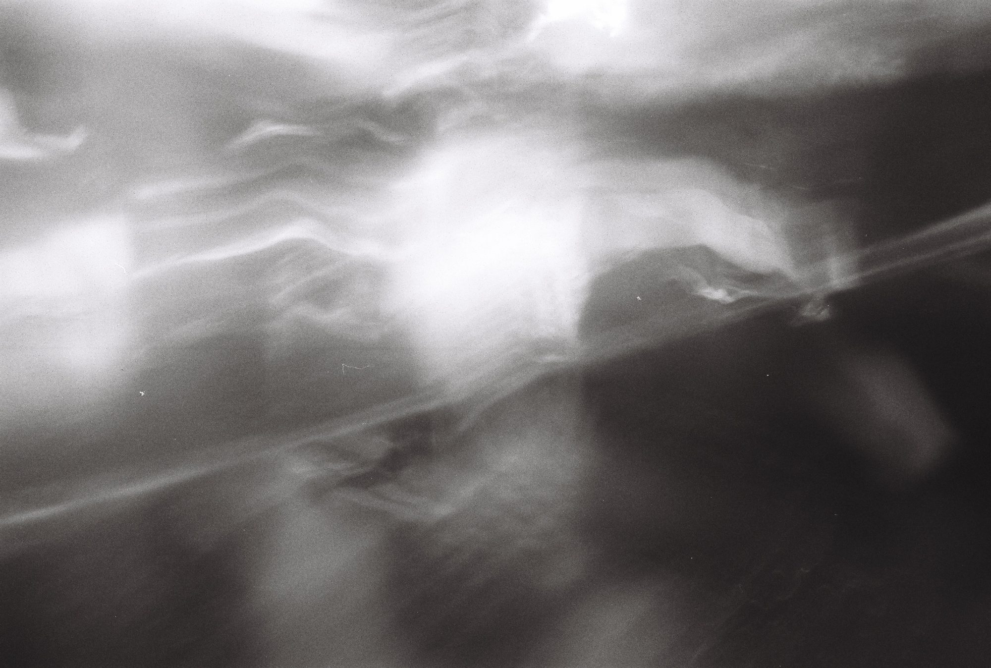 Abstract black and white image of flowing light and shadow cut by a diagonal line