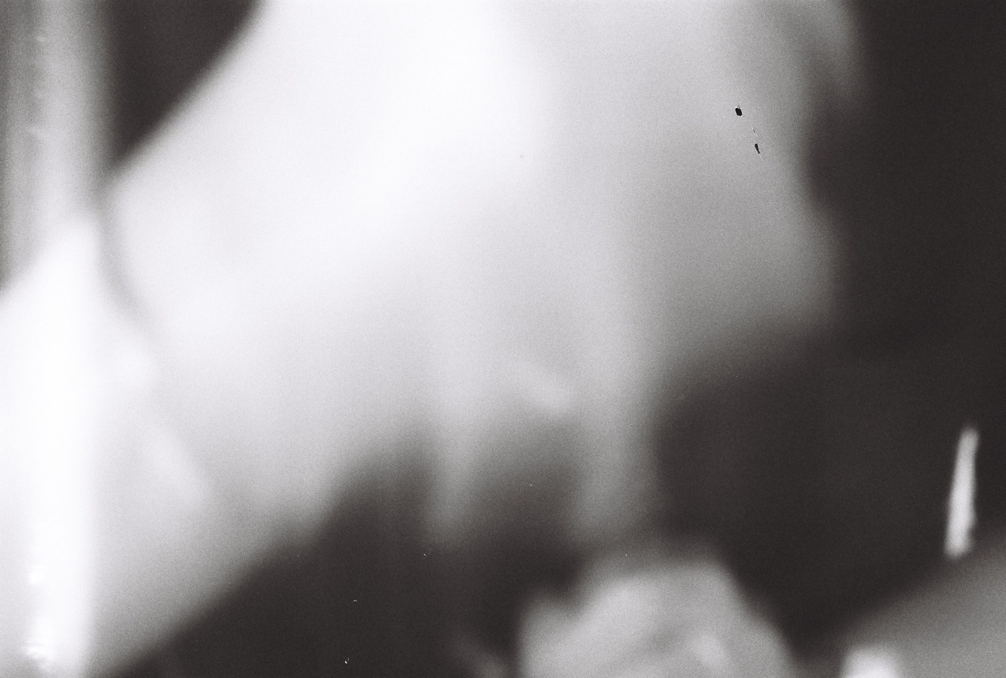 Very soft, out-of-focus black and white abstract of pale light and dark shapes