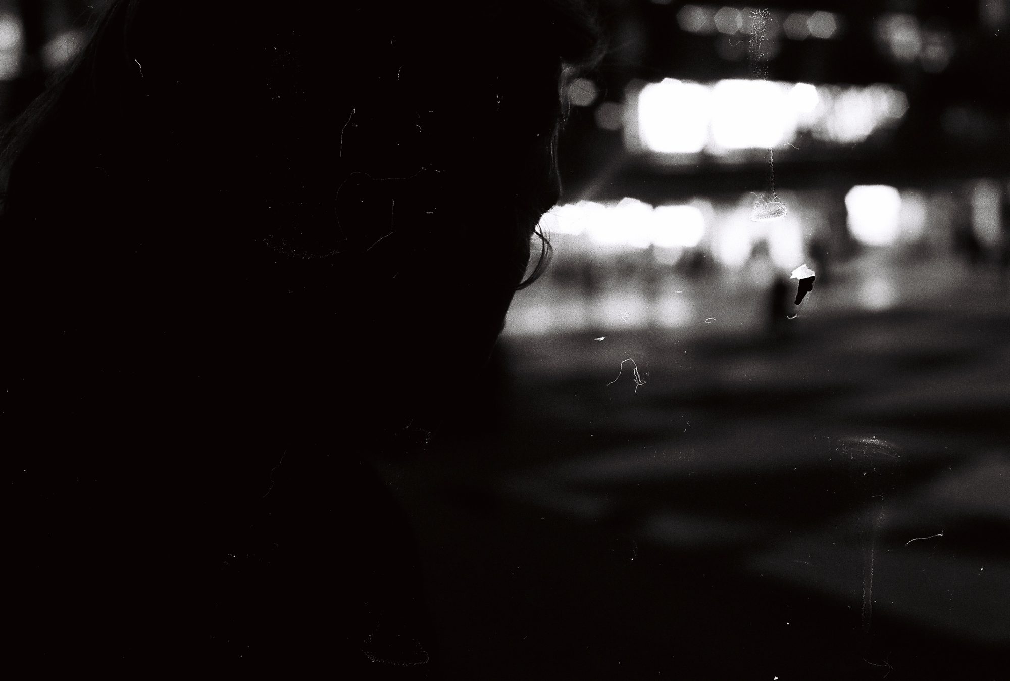 A dark silhouette against blurred city lights at night