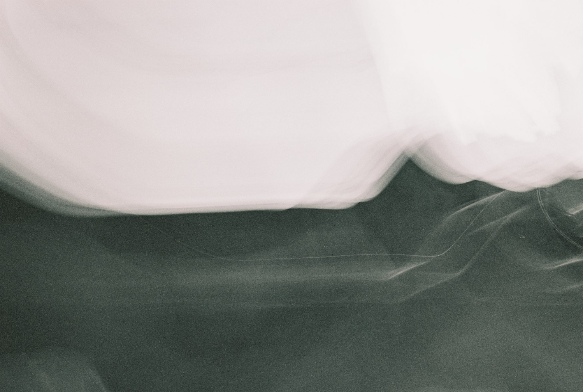 Abstract motion blur of white fabric sweeping over a dark surface