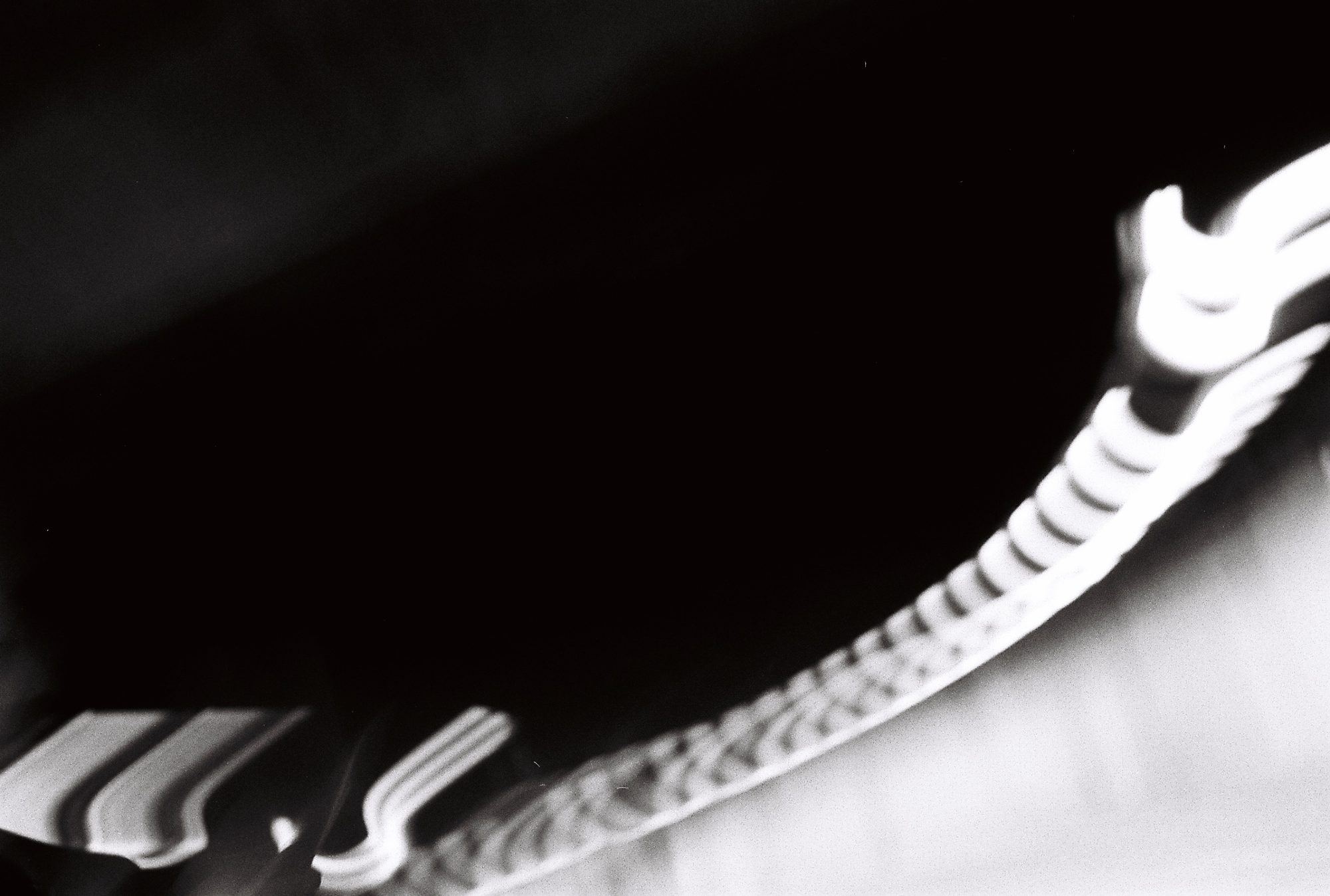 Abstract motion blur of an ornate railing curving against black
