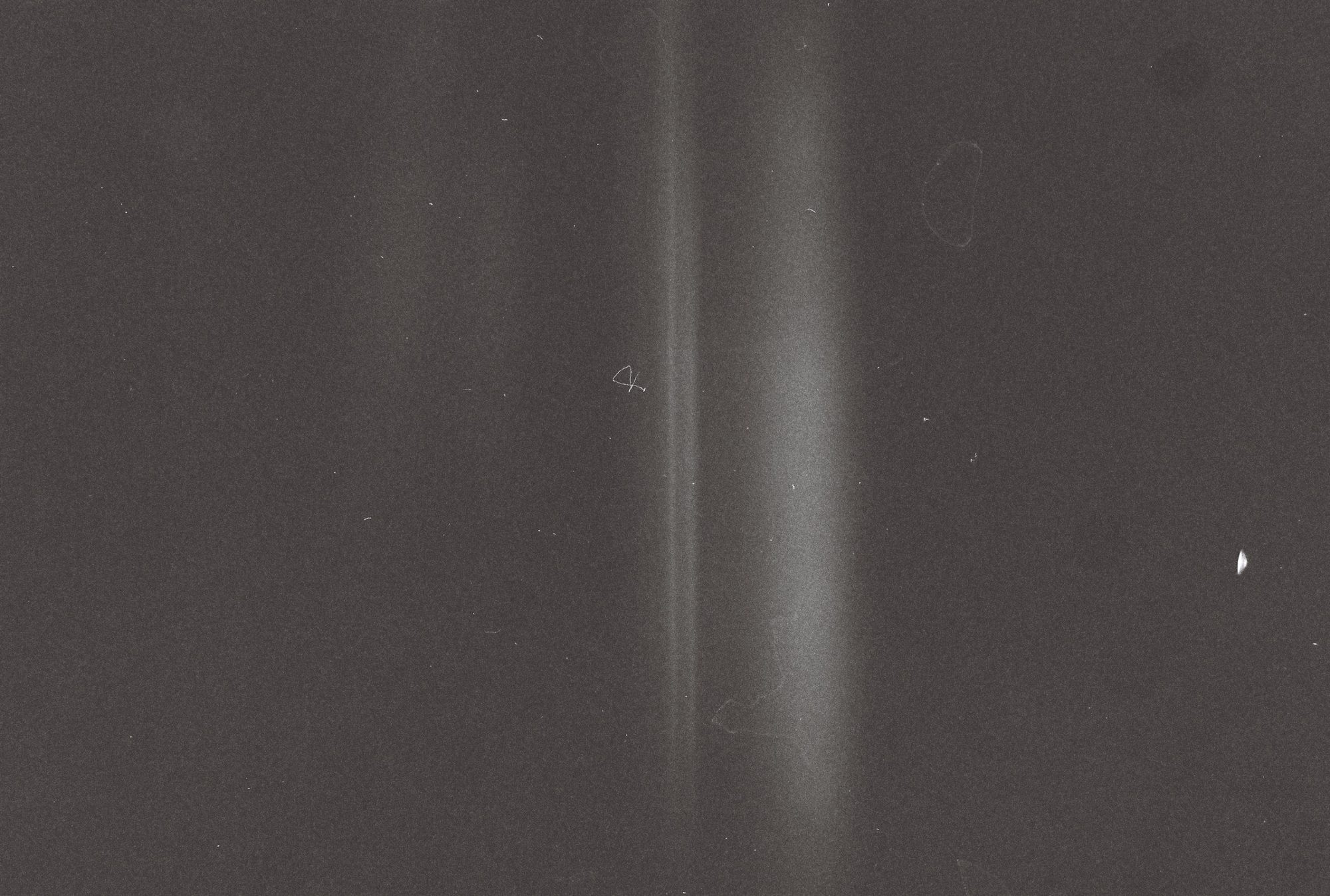 Near-abstract dark grey frame crossed by a soft vertical band of light