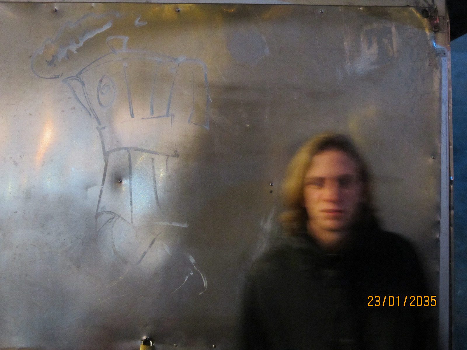 A blurred portrait in front of a scratched metal wall with a drawn figure